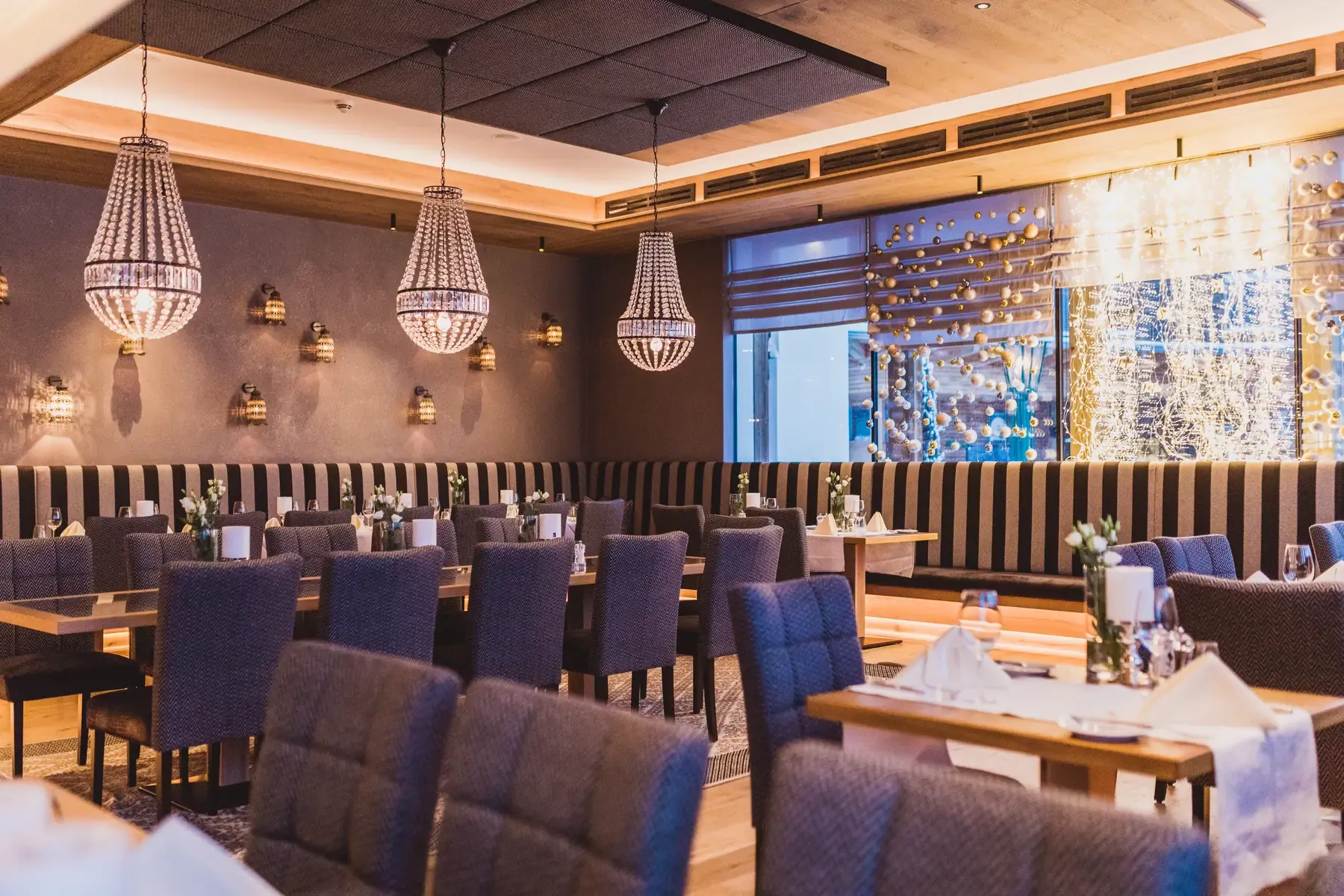 Weihnachtsfeier im Greenvieh – festlich gedecktes Restaurant mit stimmungsvoller Beleuchtung in Mieming, Tirol