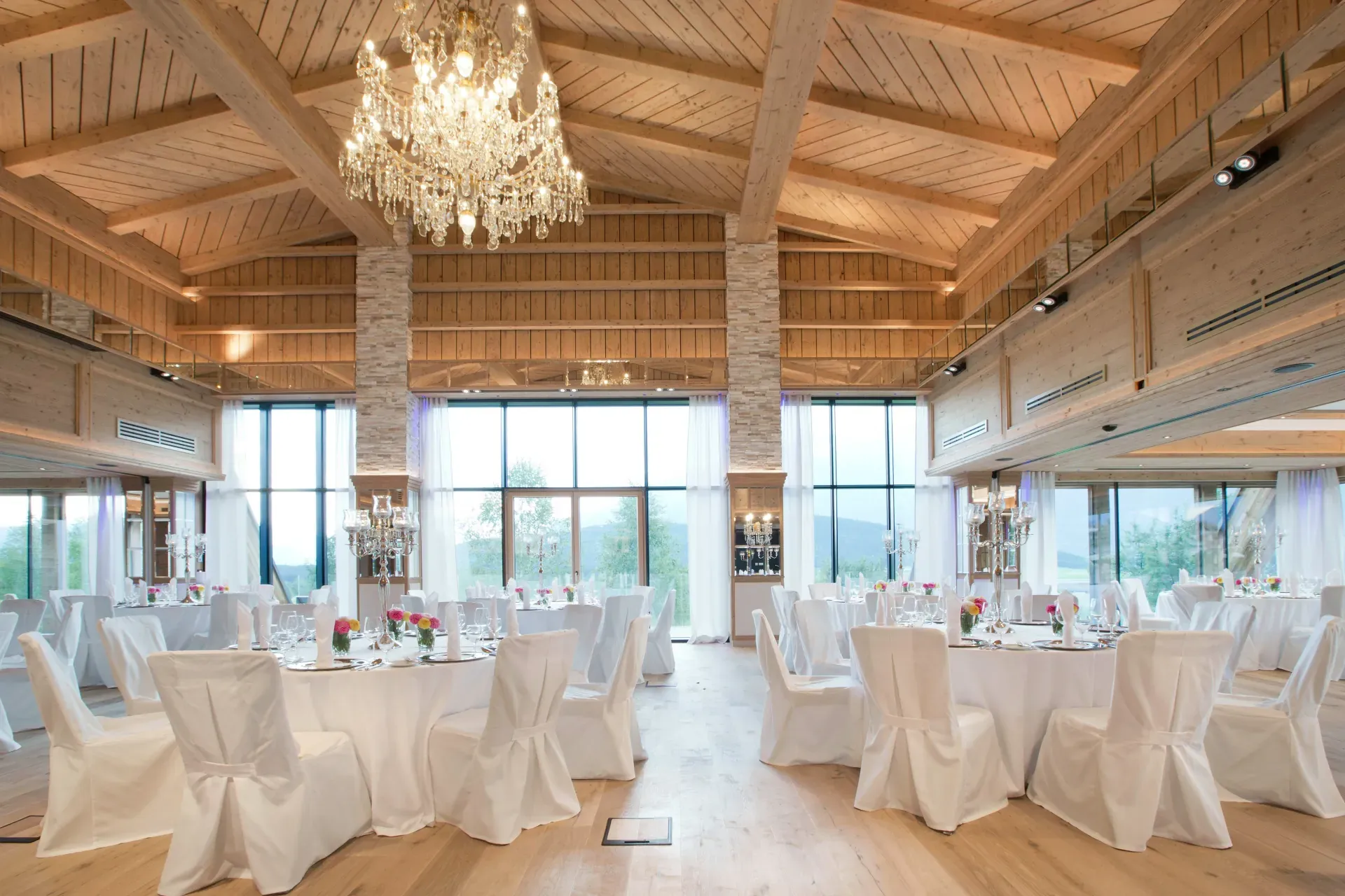 Festively set hall with chandelier for weddings in the Greenvieh Chalet in Mieming