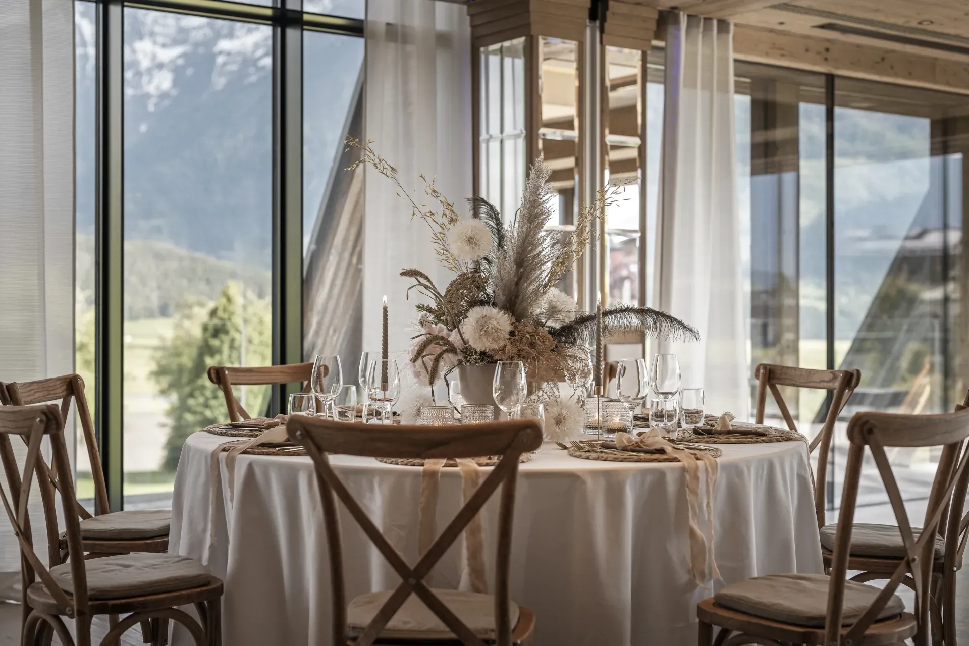 Table with dried-flower arrangement by the panorama window in the Greenvieh Chalet